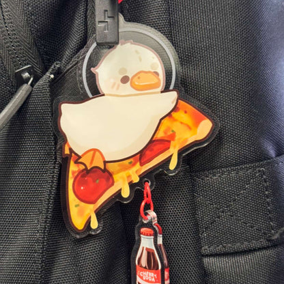 Keychain with cartoon duck on pizza and Coca-Cola bottle on a black backpack
